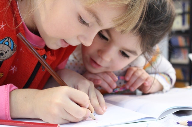 girls-on-desk-looking-at-notebook-1598231.jpg